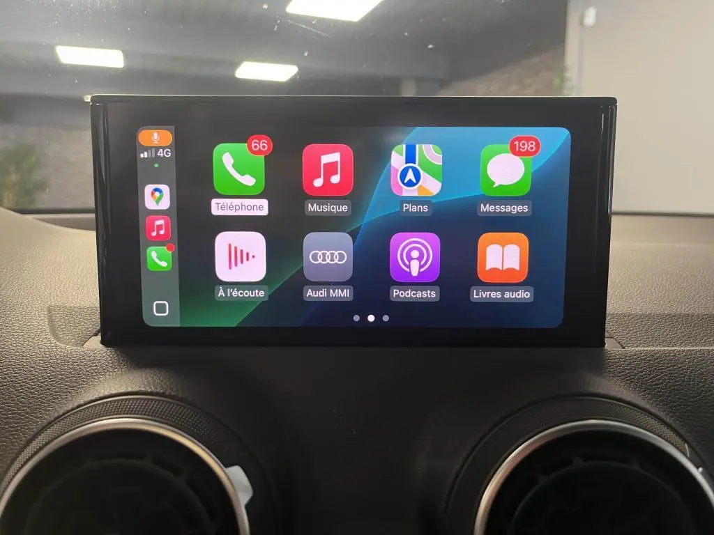 Écran tactile central de l'Audi Q2 2022 affichant l'interface Apple CarPlay avec icônes colorées, vue intérieure frontale.