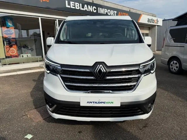 Vue frontale d'un Renault Trafic Fourgon blanc glacier avec calandre chromée et logo Renault bien visible.