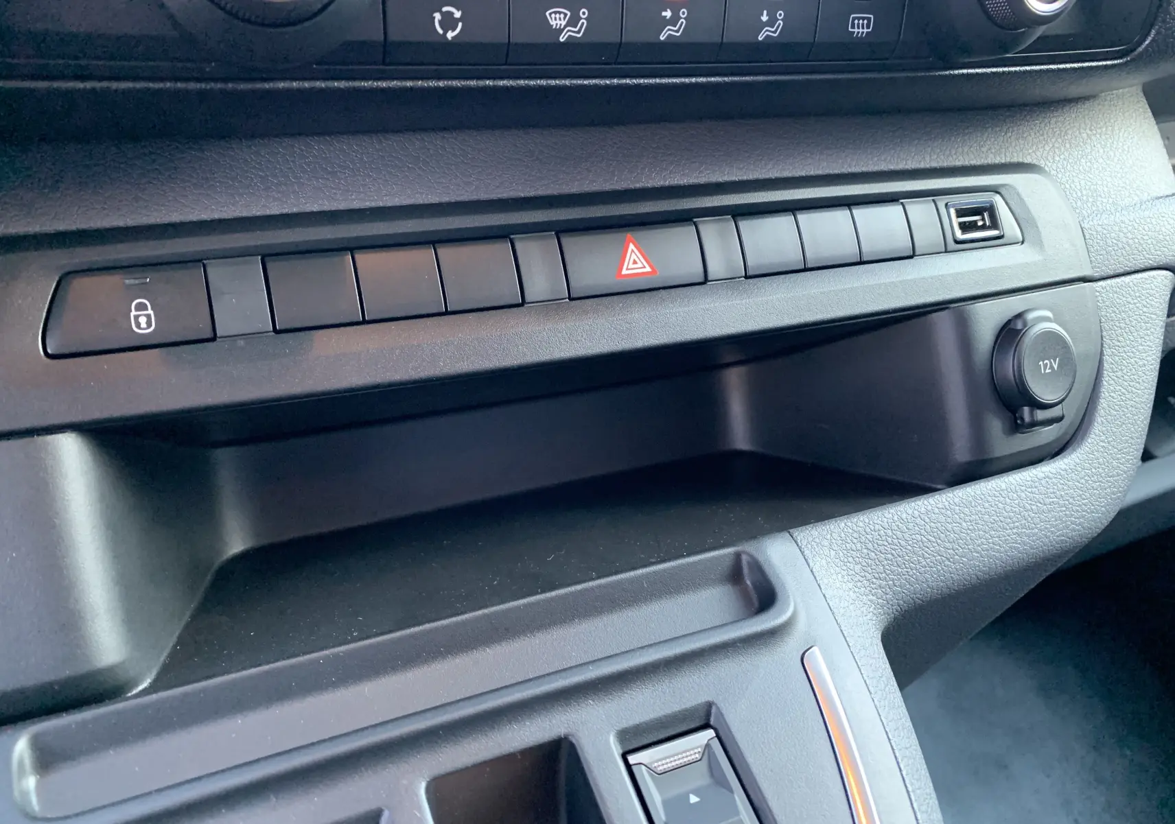 Détail de la console centrale du Fiat Scudo Combi électrique 2022, avec boutons de verrouillage, alerte et prise 12V visible.