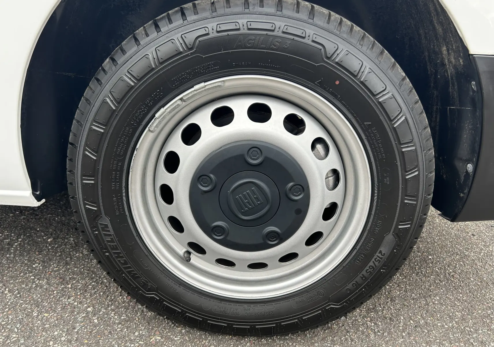 Gros plan sur la roue avant droite blanche d'un FIAT Scudo Combi électrique 2022 avec jante acier grise et logo FIAT central.