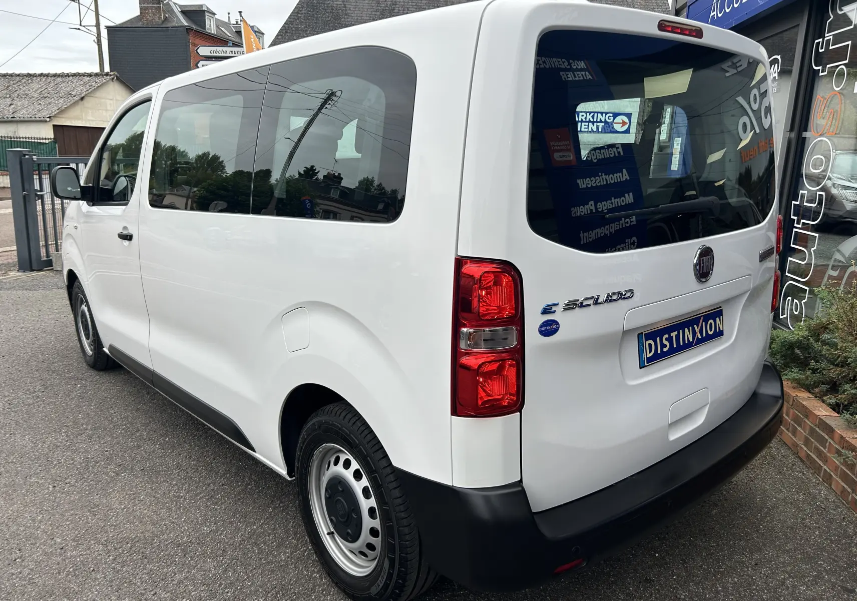 Vue 3/4 arrière droite d'un FIAT Scudo Combi blanc électrique avec vitres teintées et hayon fermé.