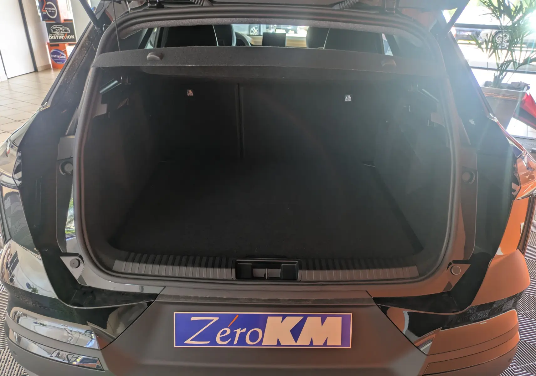 Coffre ouvert vu de l'arrière d'une Renault SYMBIOZ noir étoilé, soulignant l'espace de chargement vide.