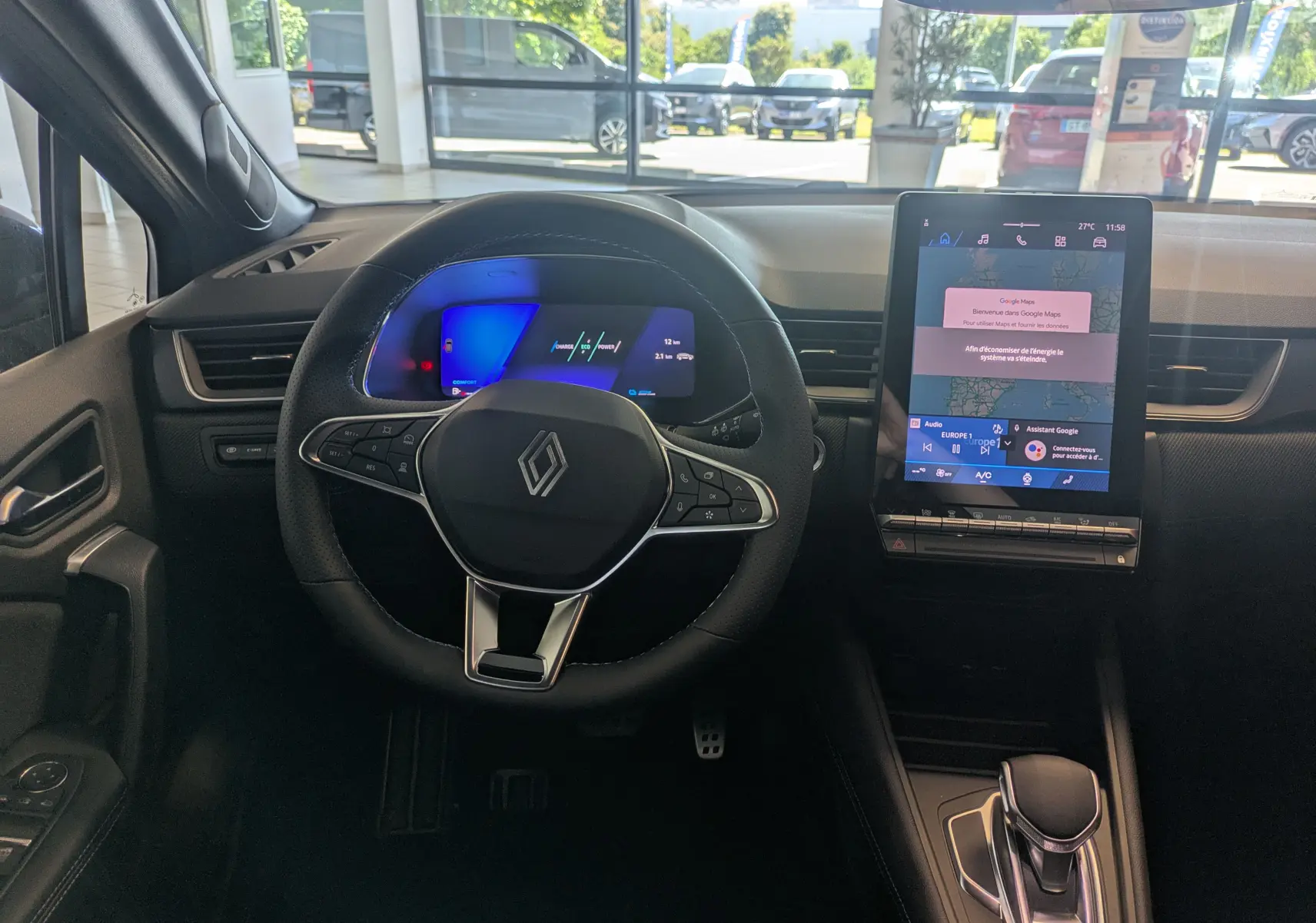 Vue intérieure centrée sur le volant cuir et l'écran tactile vertical du Renault SYMBIOZ noir étoilé 2025.