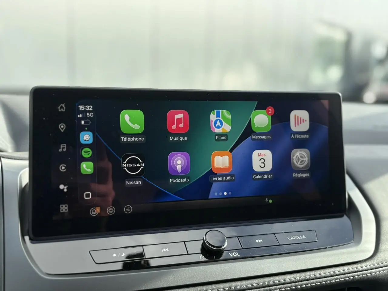 Écran tactile central du tableau de bord du Nissan Qashqai blanc nacré, affichant Apple CarPlay.