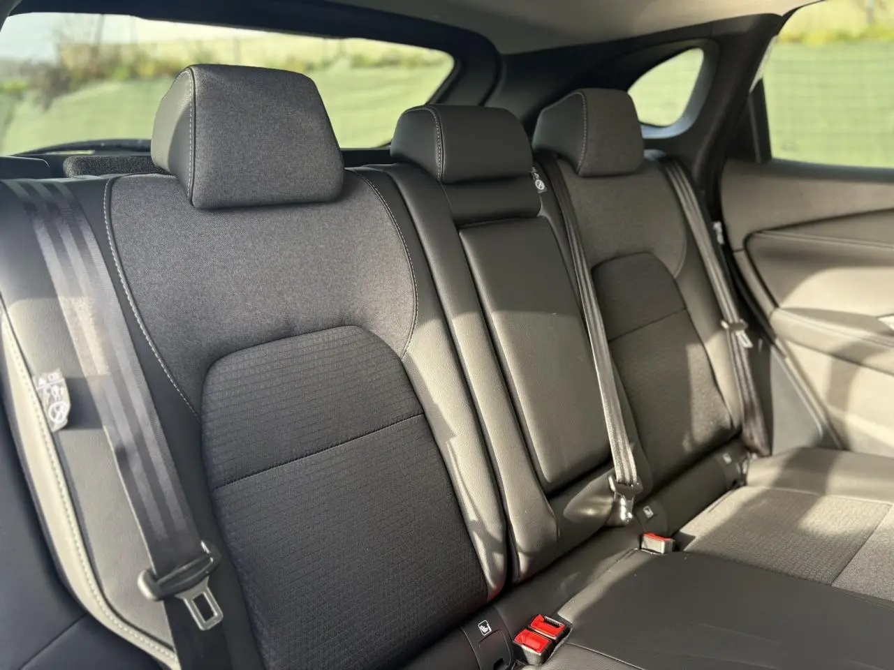 Vue intérieure des sièges arrière noirs du Nissan Qashqai III e-Power 2025, avec ceintures de sécurité visibles.