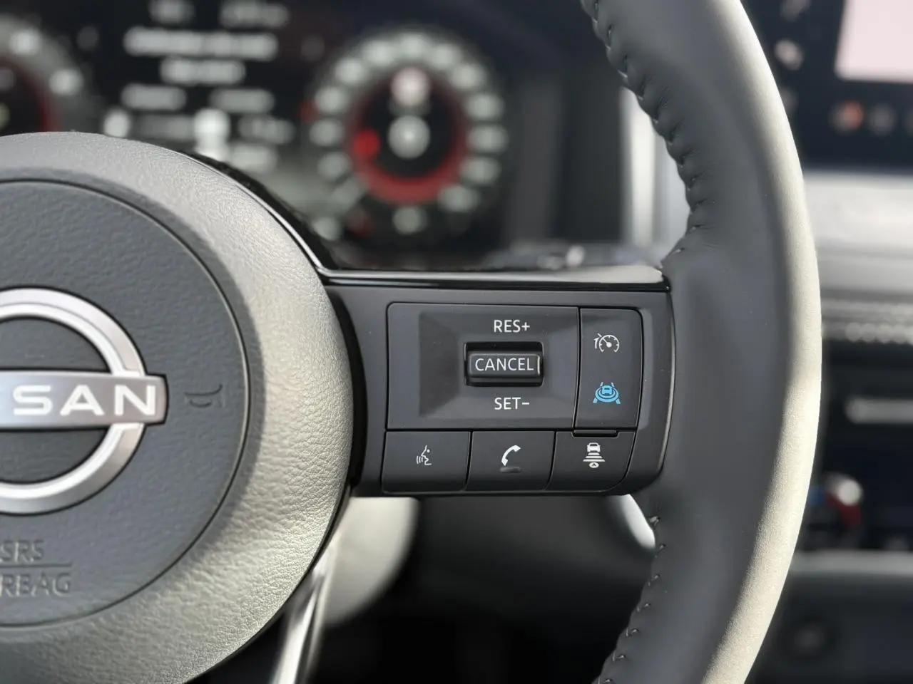 Gros plan sur le volant cuir noir du Nissan Qashqai 2025, avec commandes de régulateur et assistance à la conduite.