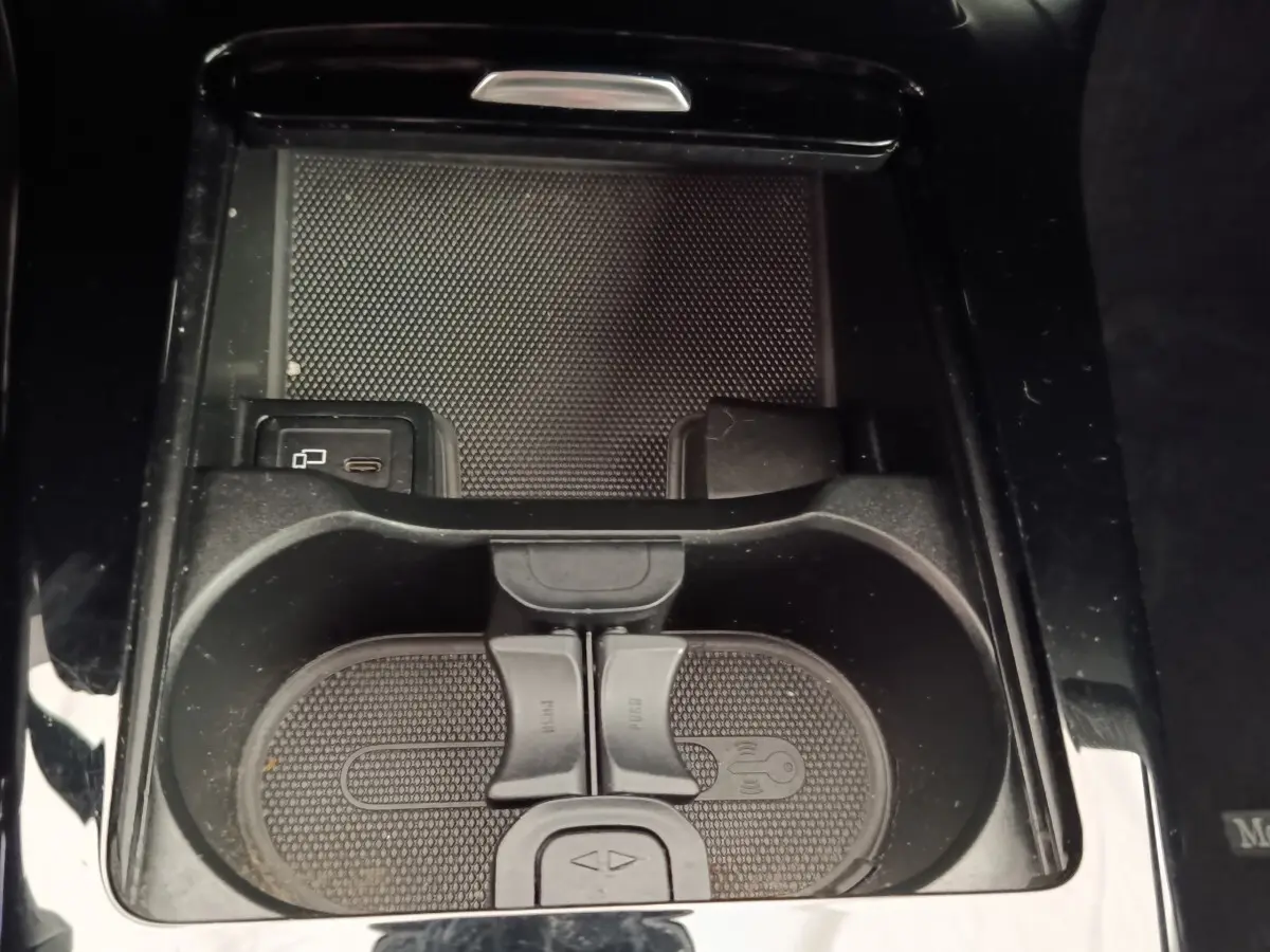 Gros plan sur la console centrale noire de la Mercedes Classe A 180 Business Line avec porte-gobelets et prise USB visible.