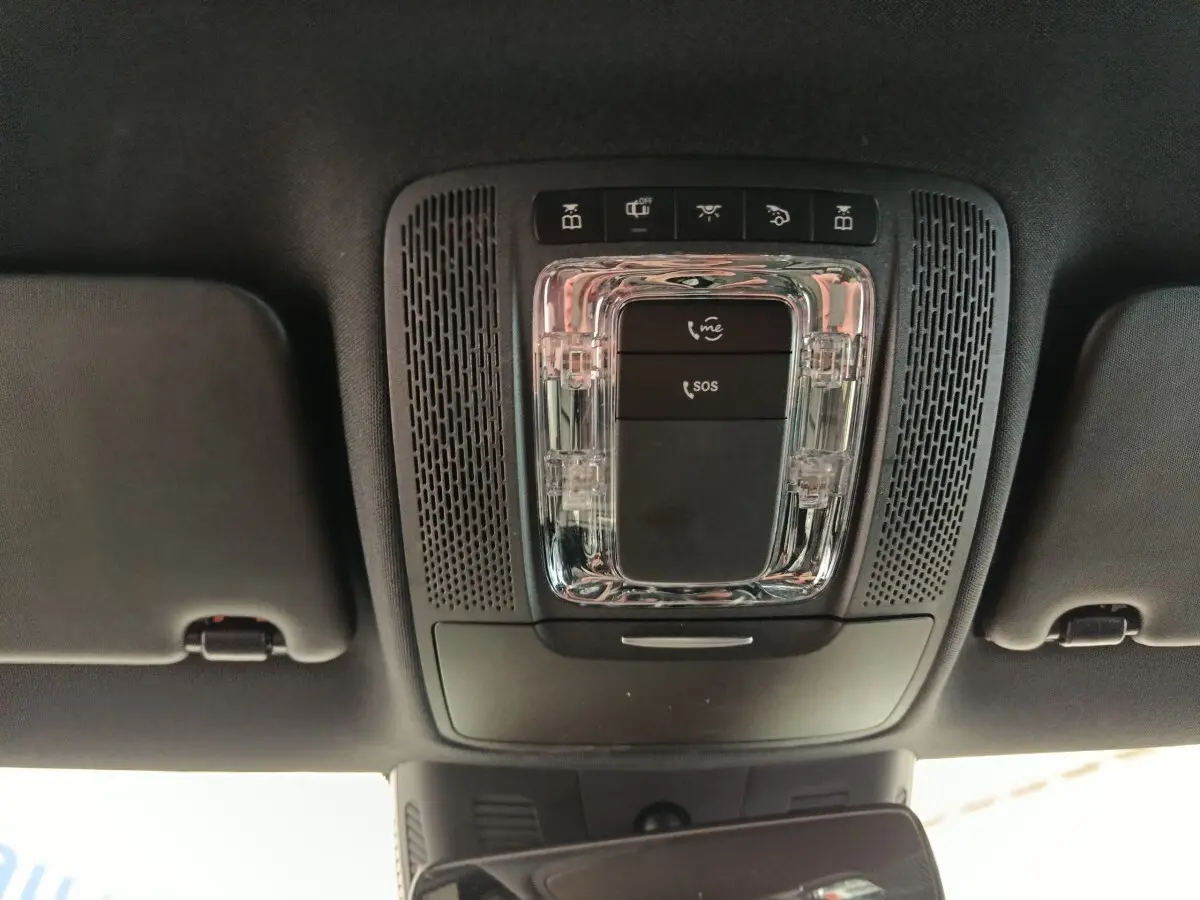 Vue en plongée sur le plafonnier noir avec commandes SOS et éclairage intérieur de la Mercedes Classe A gris clair.