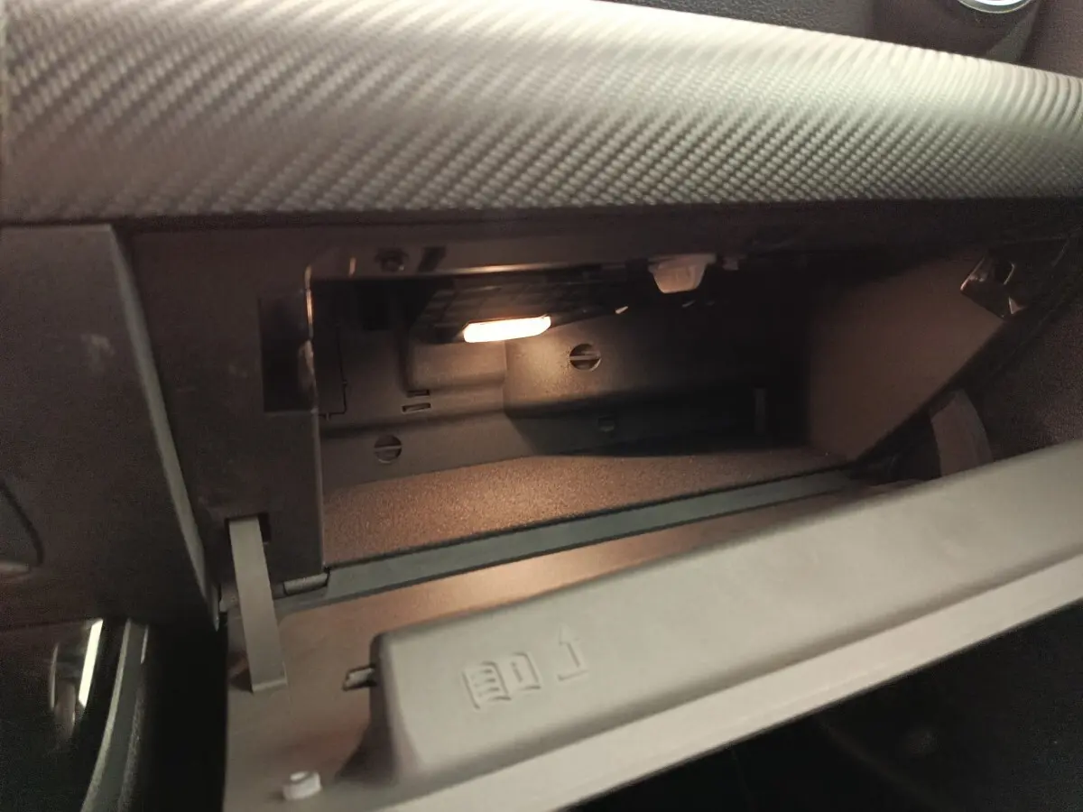 Gros plan sur la boîte à gants ouverte du Mercedes Classe A 180 Business Line gris clair, intérieur noir.