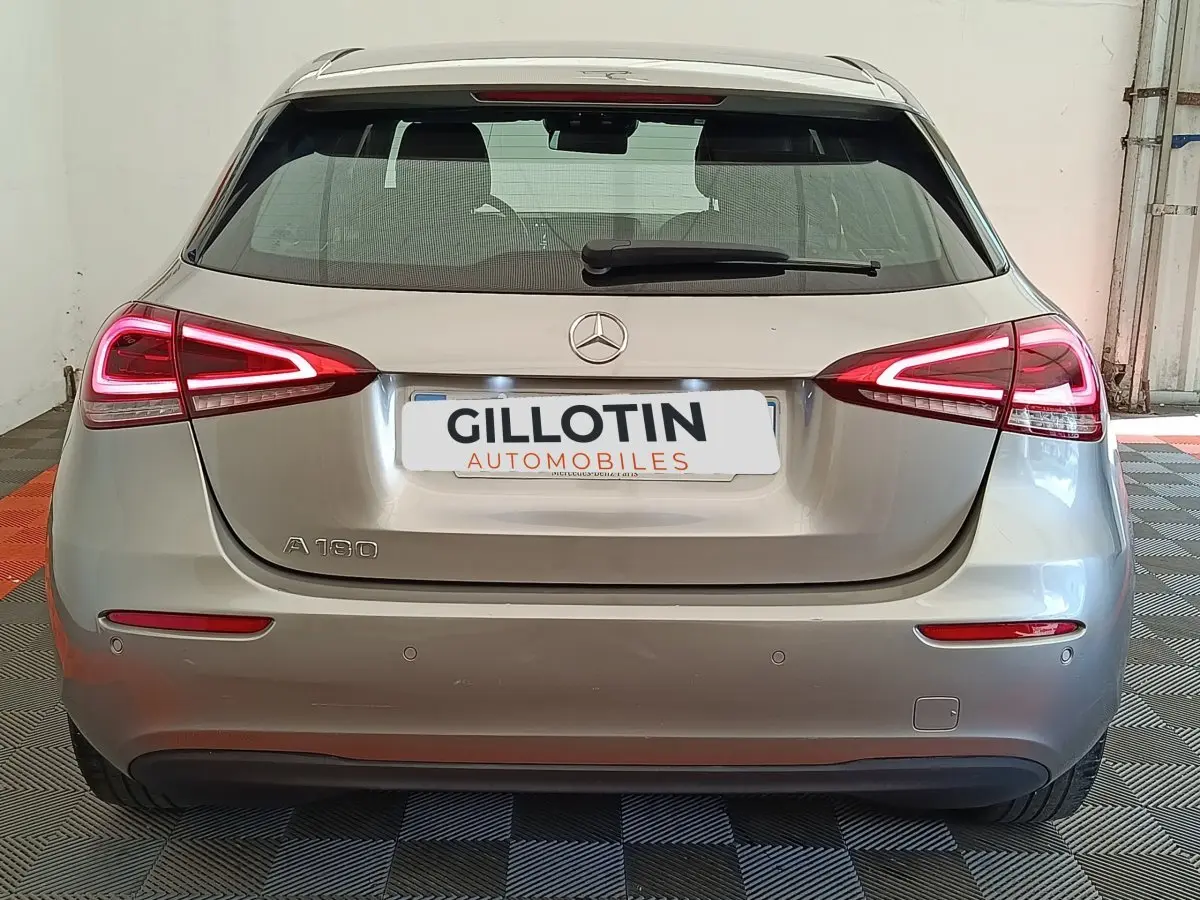 Vue arrière d'une Mercedes Classe A 180 Business Line gris clair avec feux LED et logo Mercedes visible.