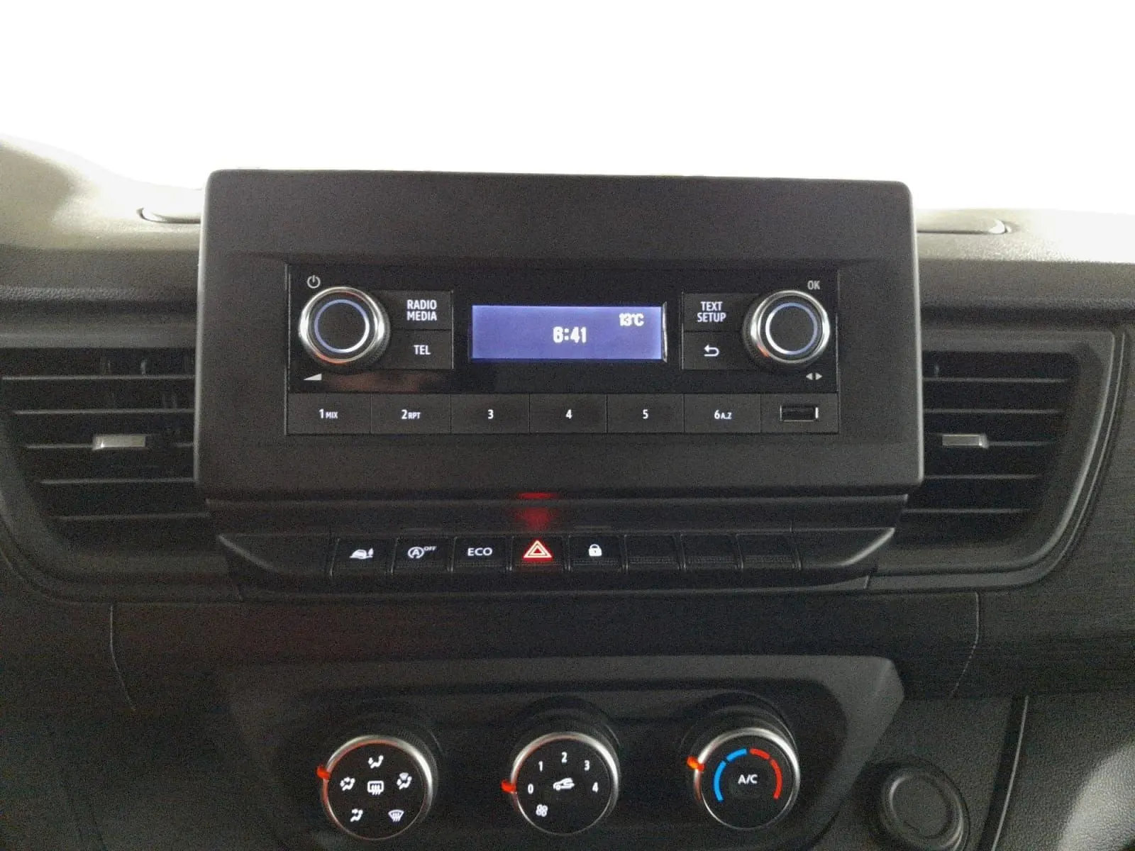 Vue rapprochée du tableau de bord du Renault Trafic Fourgon 2024, avec commandes radio et climatisation visibles.