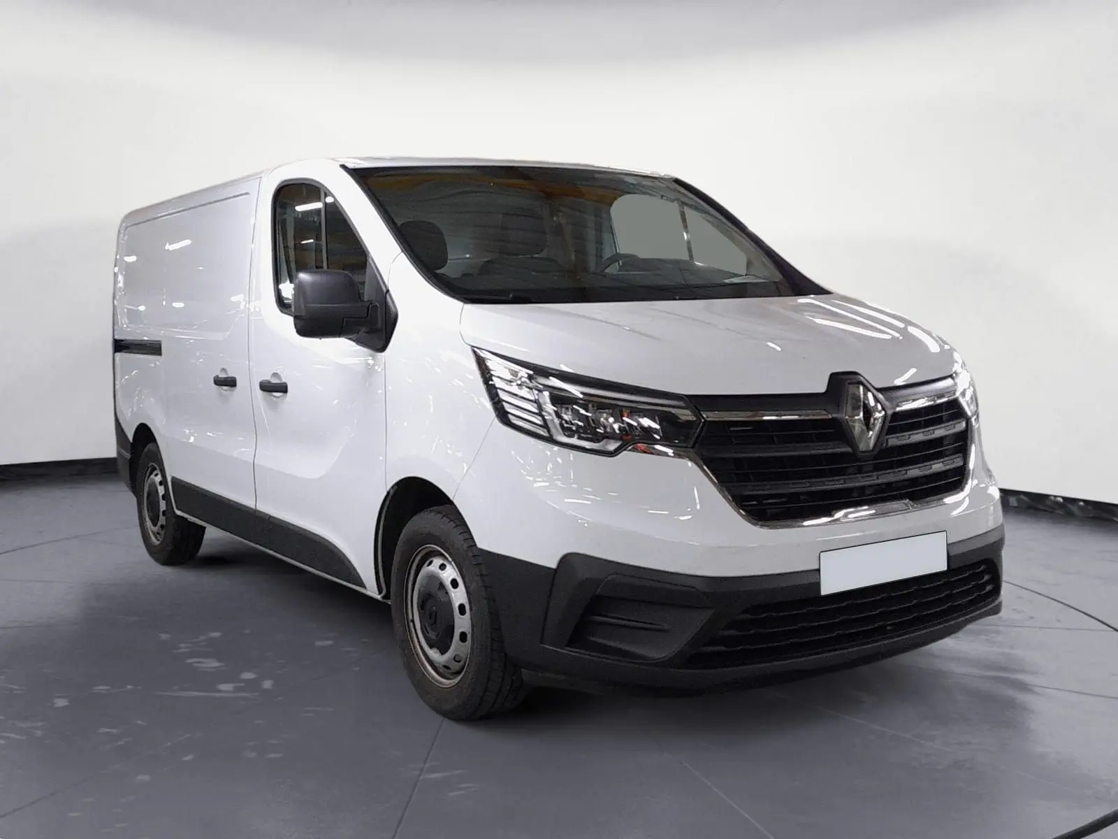 Vue 3/4 avant d’un Renault Trafic Fourgon blanc minéral avec calandre noire et jantes acier, sur fond neutre intérieur.