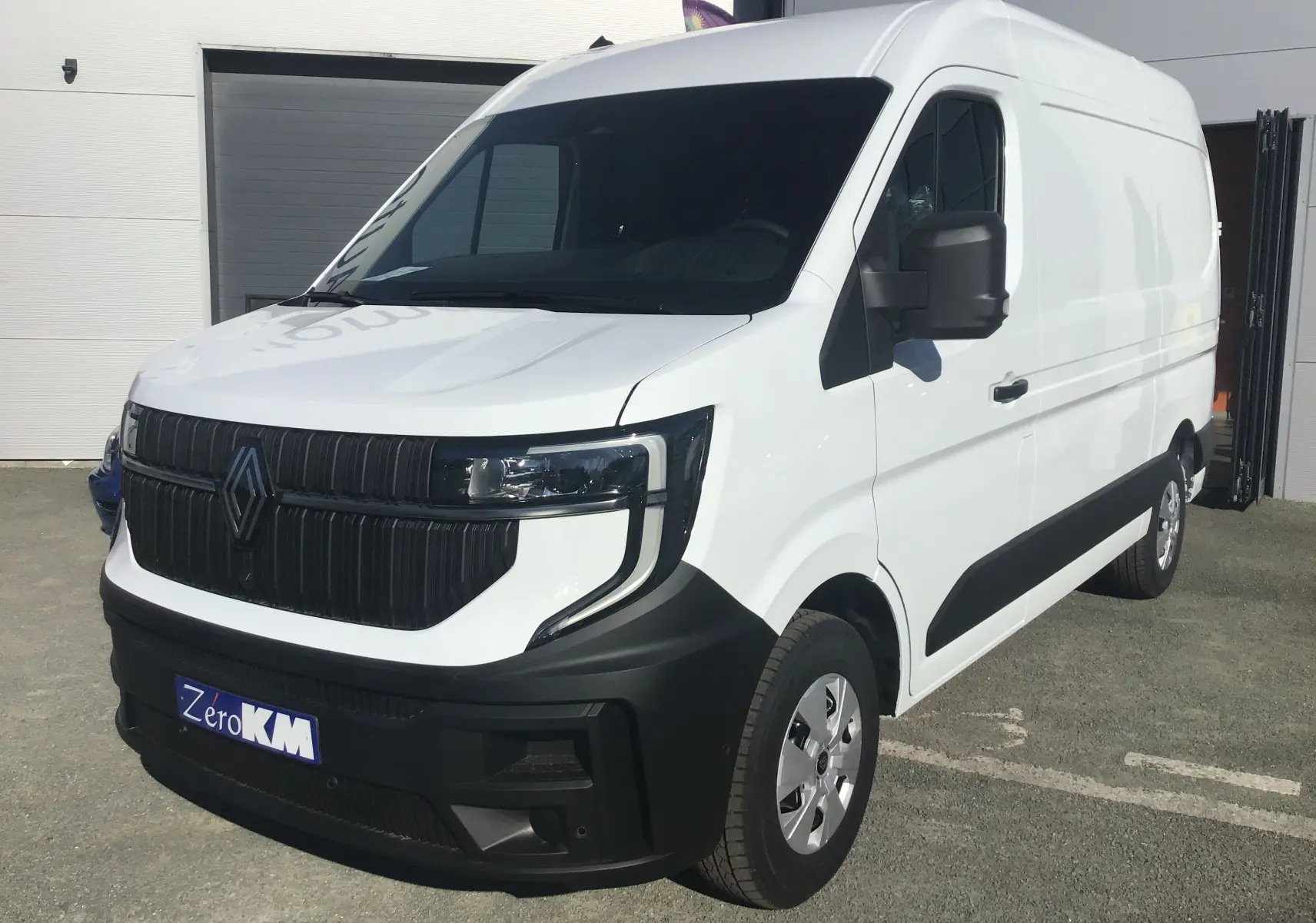 Vue 3/4 avant droite du Renault Master L2H2 blanc 2025 avec calandre noire et pare-chocs contrasté noir.