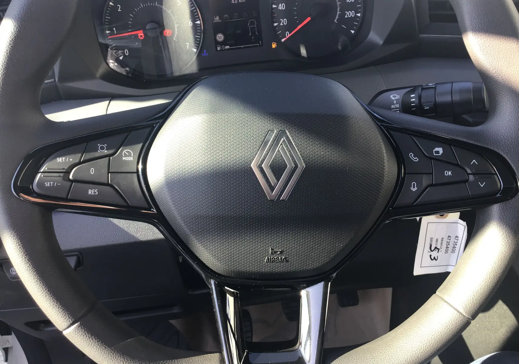 Volant Renault Master 2025 en gros plan avec commandes intégrées et tableau de bord visible en arrière-plan.