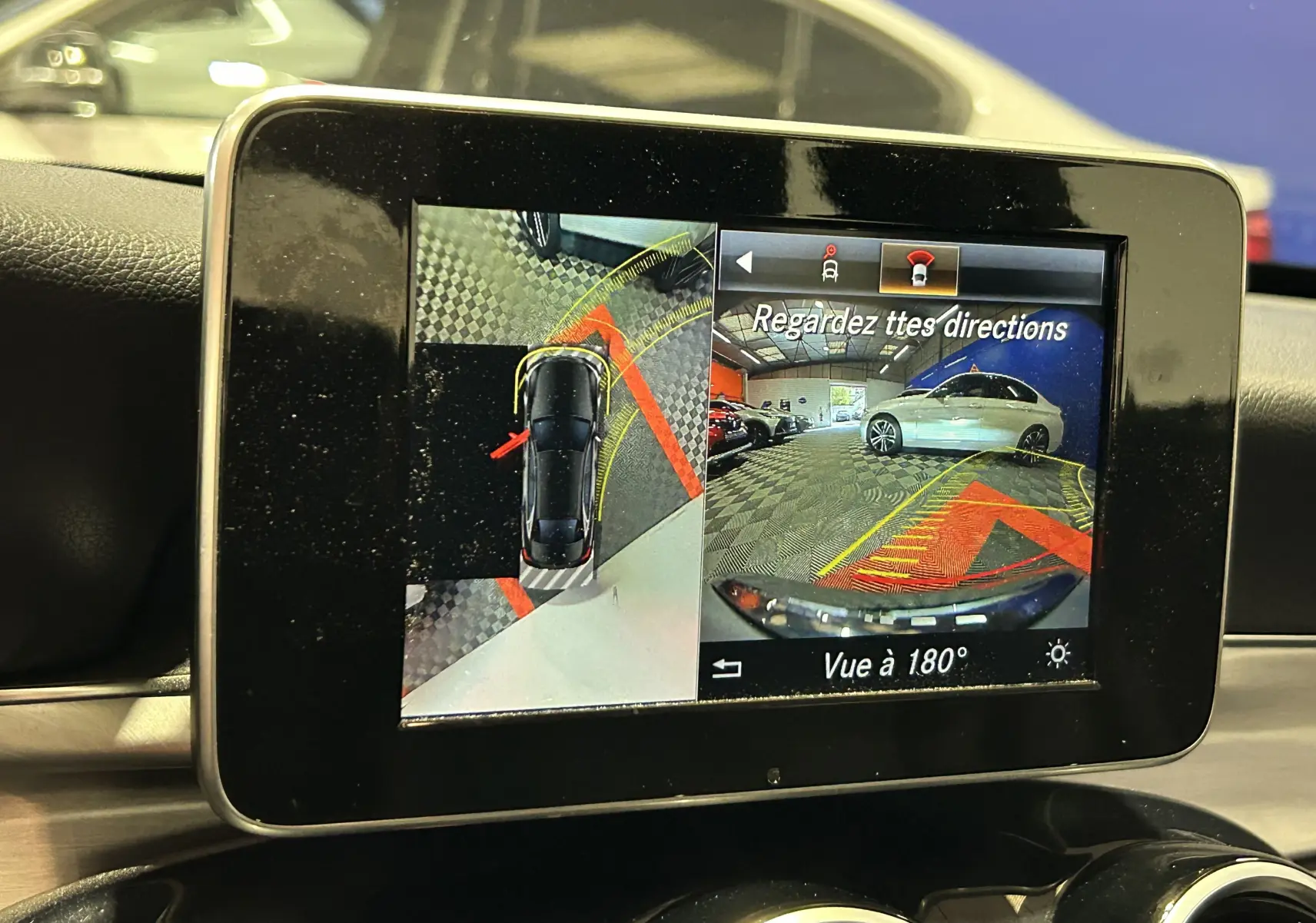 Écran de caméra 360° dans Mercedes Classe C 200d bleu, vue intérieure sur affichage d'aide au stationnement.