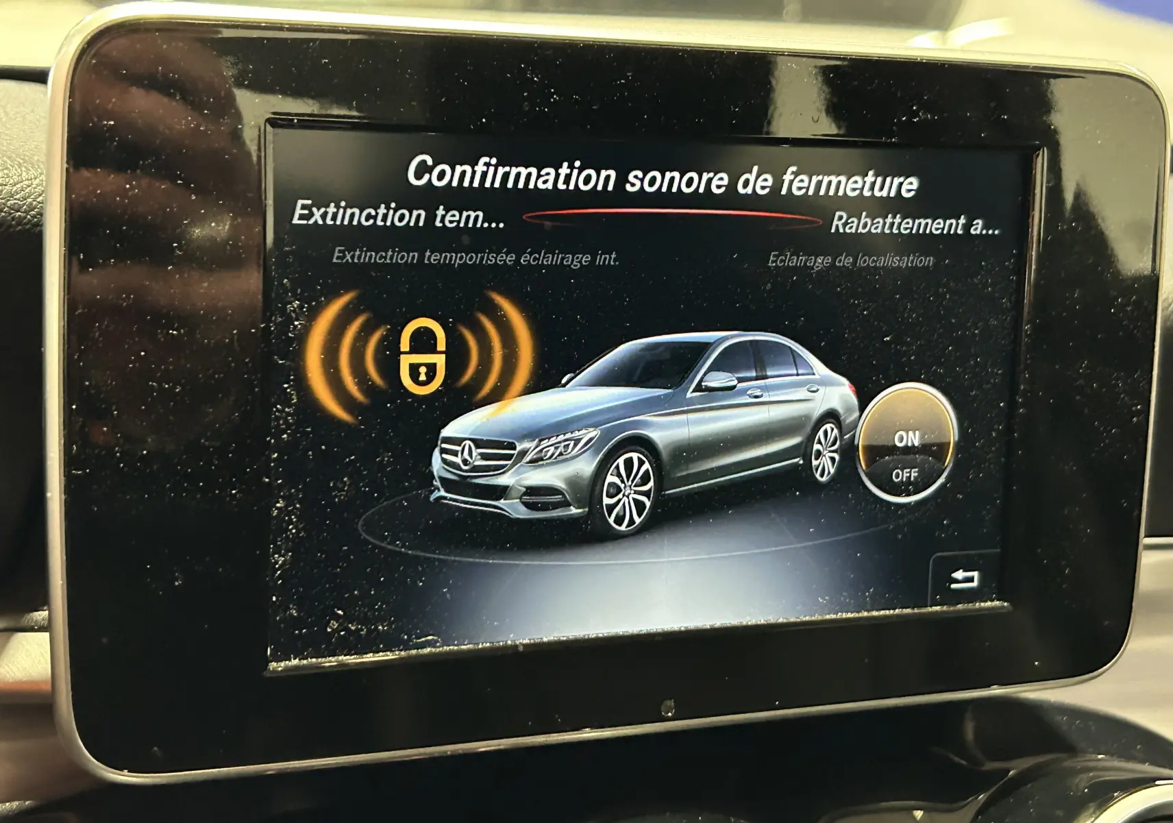 Écran de bord montrant une Mercedes Classe C bleue en vue latérale droite avec icône de verrouillage activée.