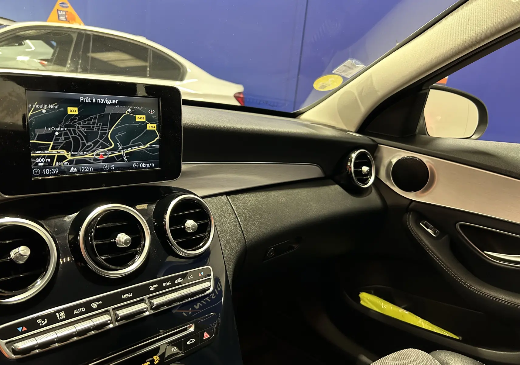 Intérieur de la Mercedes Classe C 200d 2018, vue côté passager, tableau de bord noir avec écran GPS allumé.