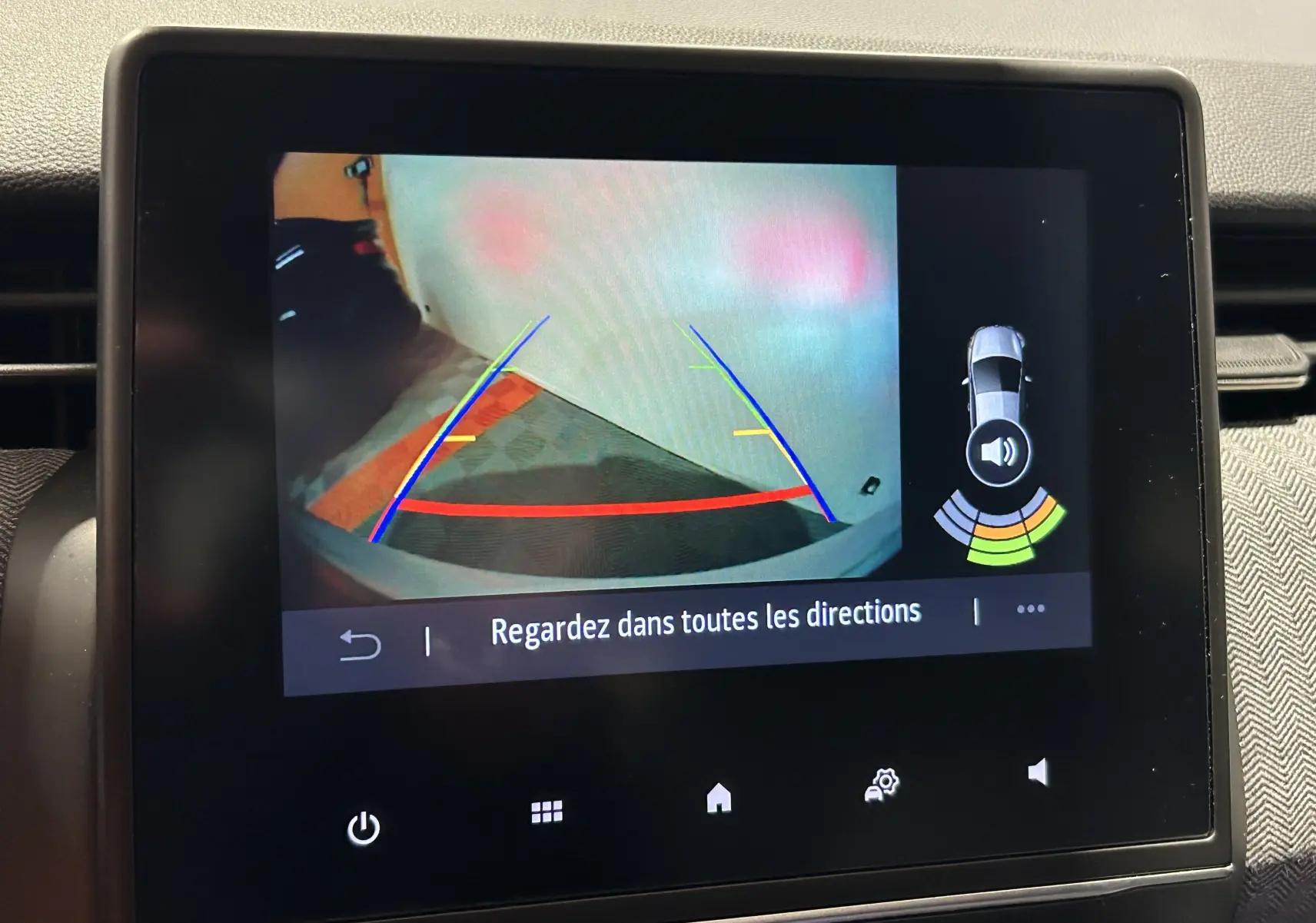 Écran tactile de la Renault Clio V E-Tech montrant la caméra de recul avec guidage coloré et avertissement sonore.