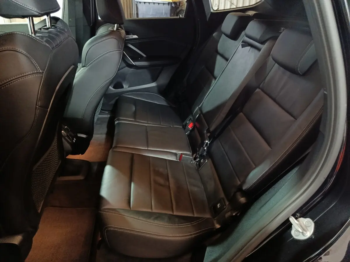 Vue intérieure côté droit montrant la banquette arrière noire en cuir du BMW X1 xDrive23i M Sport 2023.