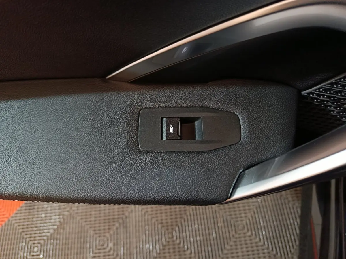 Détail de l'interrupteur de verrouillage des portes sur la porte intérieure côté conducteur d'un BMW X1 noir 2023.