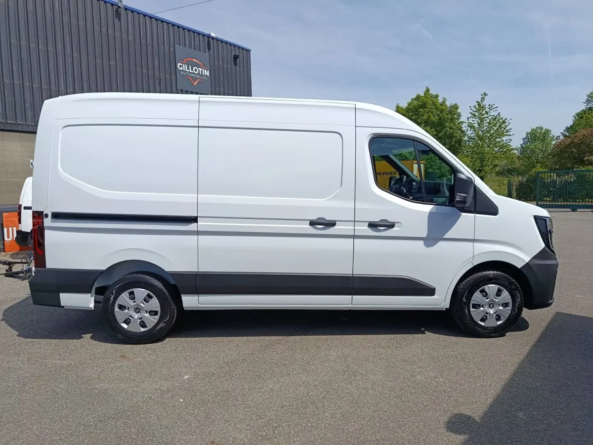 Vue de profil côté droit d’un Renault Master blanc 2025, fourgon utilitaire avec détails noirs sur bas de caisse et pare-chocs.
