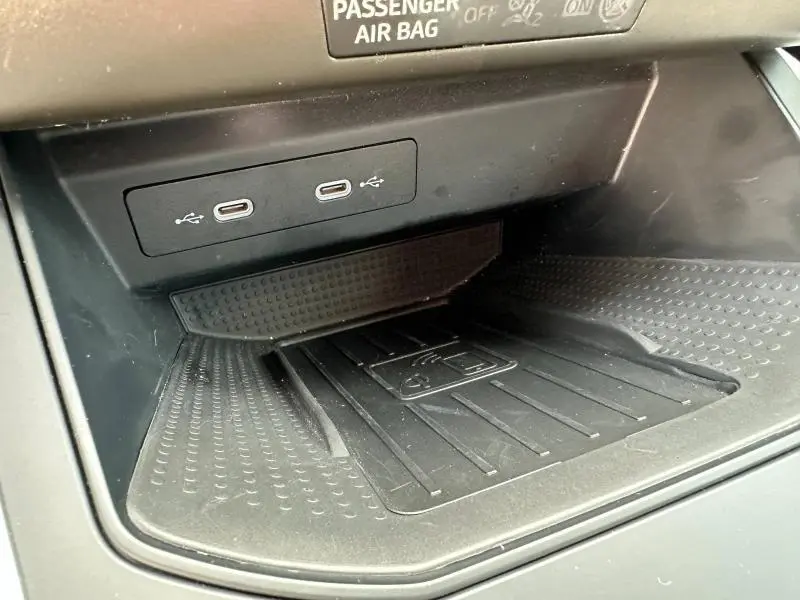 Gros plan intérieur sur la console centrale noire du SEAT Arona 2025, avec deux ports USB-C et un espace de rangement antidérapant.