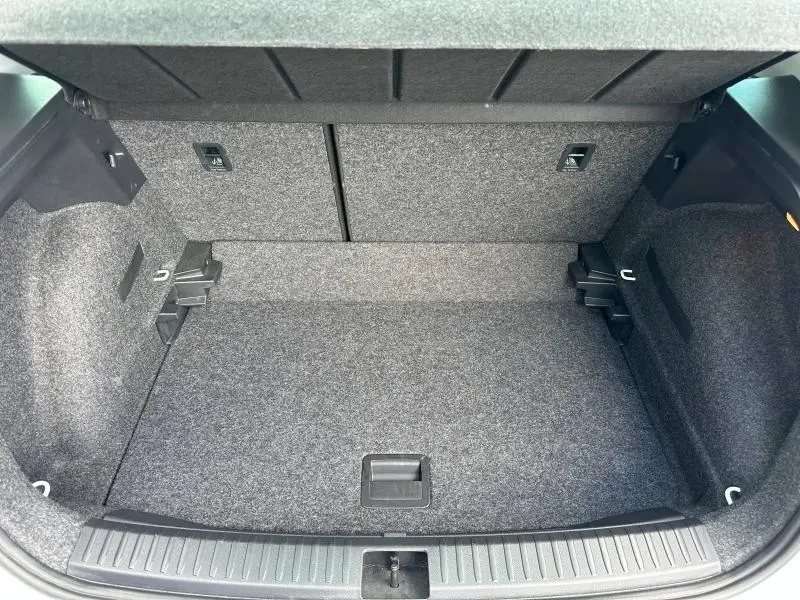 Coffre ouvert vu de dessus du SEAT Arona 2025, revêtement gris et banquette arrière rabattable.