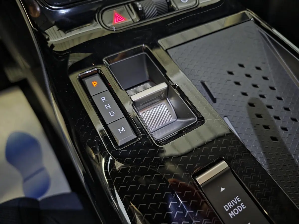 Gros plan sur la console centrale noire brillante avec sélecteur de boîte auto et bouton Drive Mode du Citroën C5 Aircross vert.