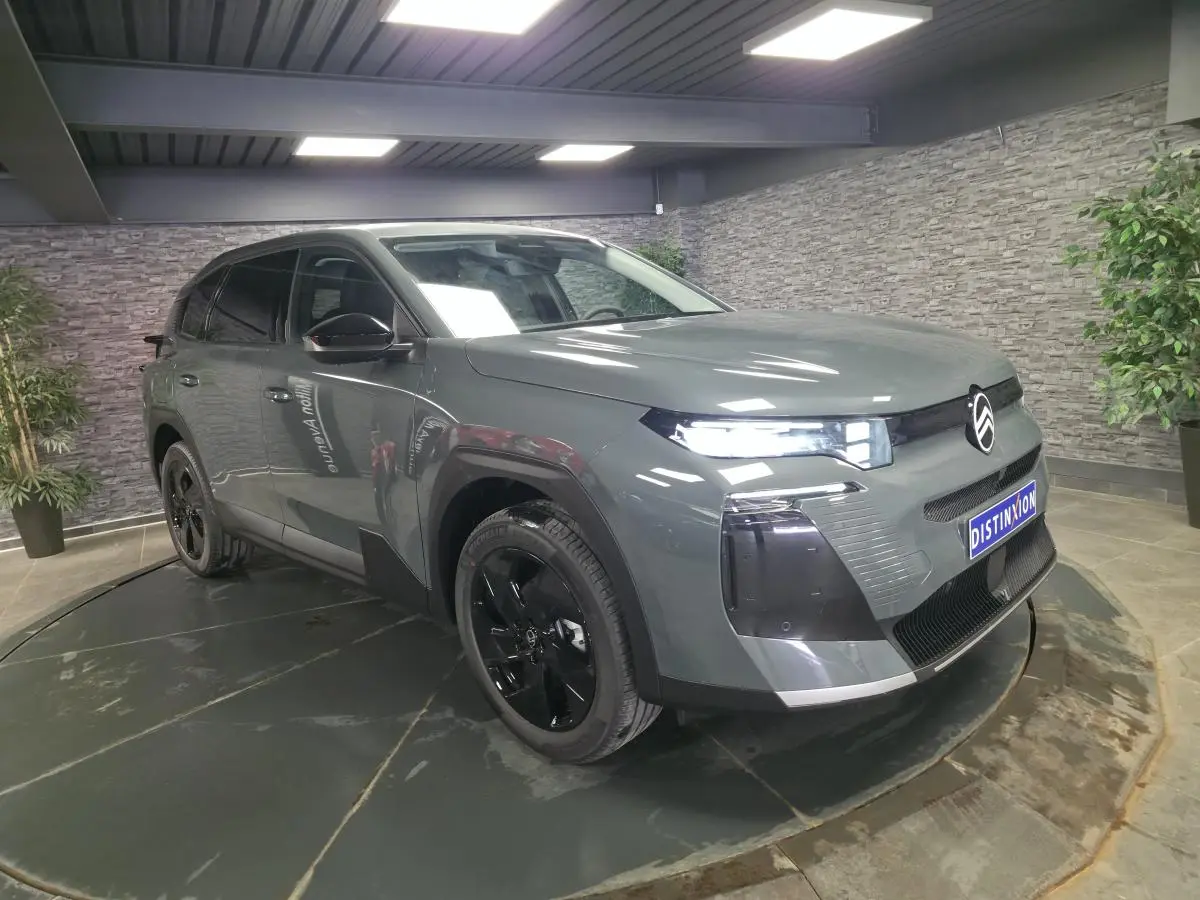 Citroën C5 Aircross gris 3/4 avant droit avec jantes noires et calandre noire brillante en intérieur showroom.
