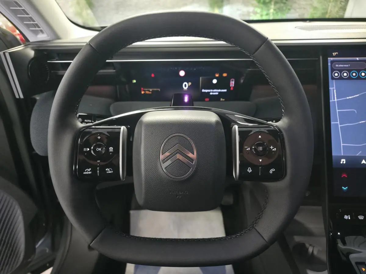 Vue frontale du volant noir multifonctions de la Citroën C5 Aircross 1.2i Hybride avec tableau de bord numérique et écran tactile.