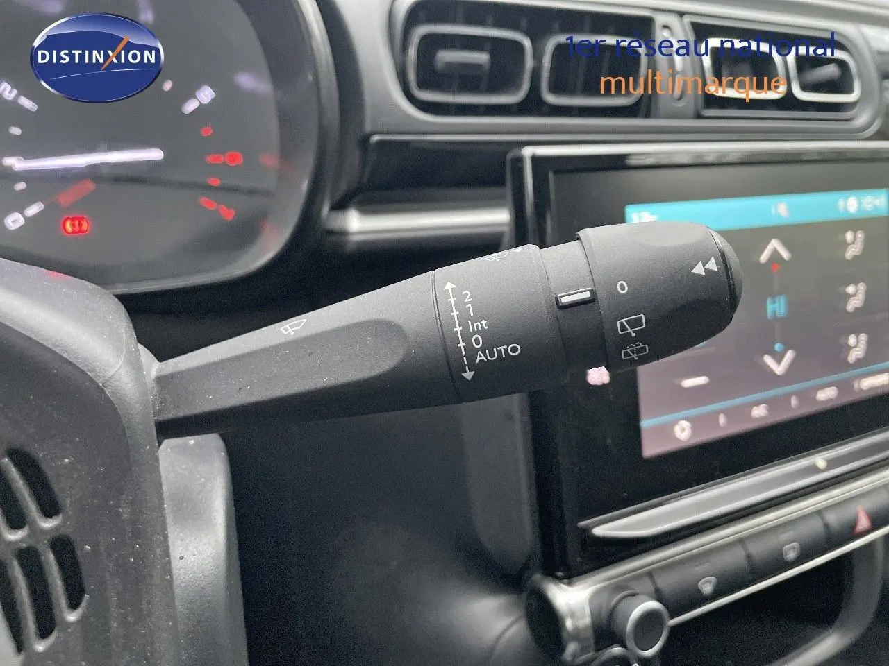 Gros plan sur la commande d'essuie-glace à gauche du volant dans l'habitacle d'une Citroën C3 gris acier toit noir 2023.
