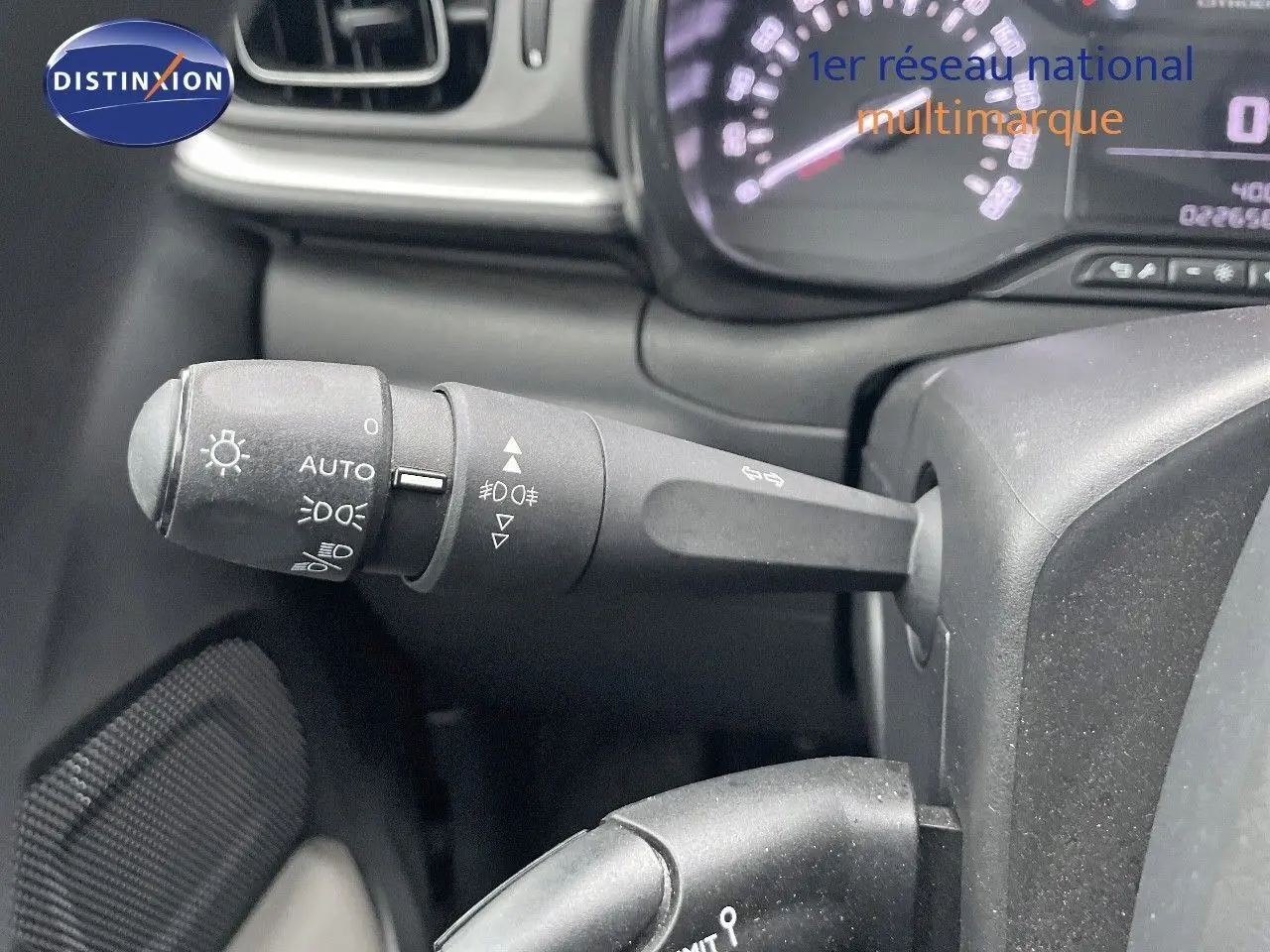 Gros plan sur la manette des feux et clignotants du tableau de bord d'une Citroën C3 gris acier toit noir 2023.