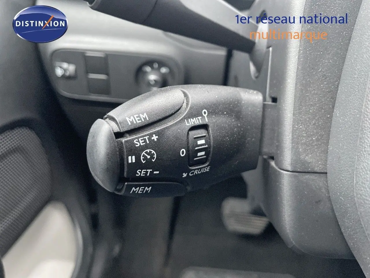 Gros plan sur la commande de régulateur de vitesse d'une Citroën C3 2023 gris acier avec toit noir, côté gauche du volant.