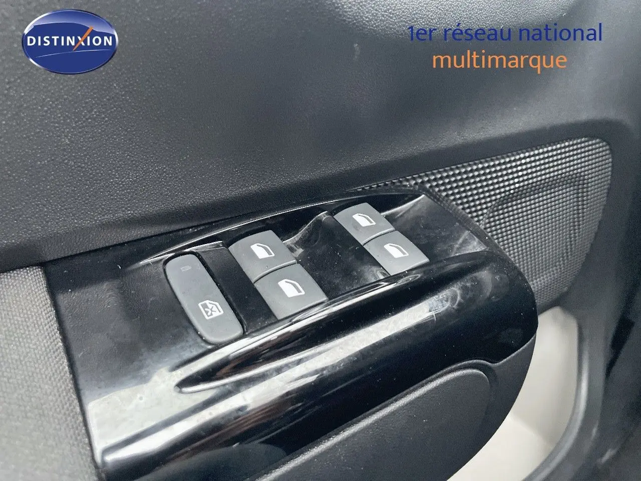 Gros plan sur les commandes des vitres électriques côté conducteur d'une Citroën C3 gris acier avec toit noir.