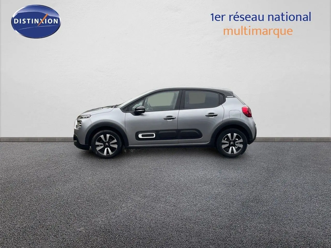 Profil latéral droit d'une Citroën C3 2023 gris acier métal avec toit noir et protections de porte noires.