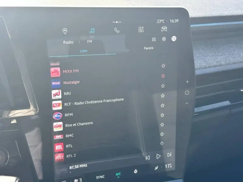 Écran tactile central du tableau de bord du Renault Espace 2024 gris Schiste affichant les stations radio FM.