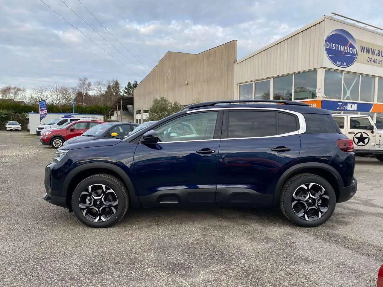 Vue de profil côté gauche d'un Citroën C5 Aircross 2025 bleu éclipse avec jantes noires et toit noir.