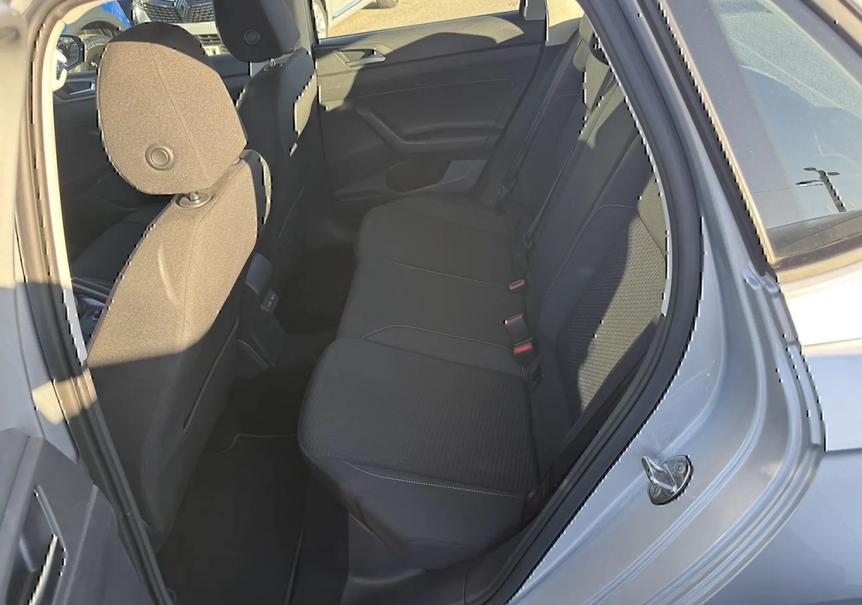 Vue intérieure côté arrière droit montrant les sièges arrière noirs du Volkswagen Polo gris métal 2021.