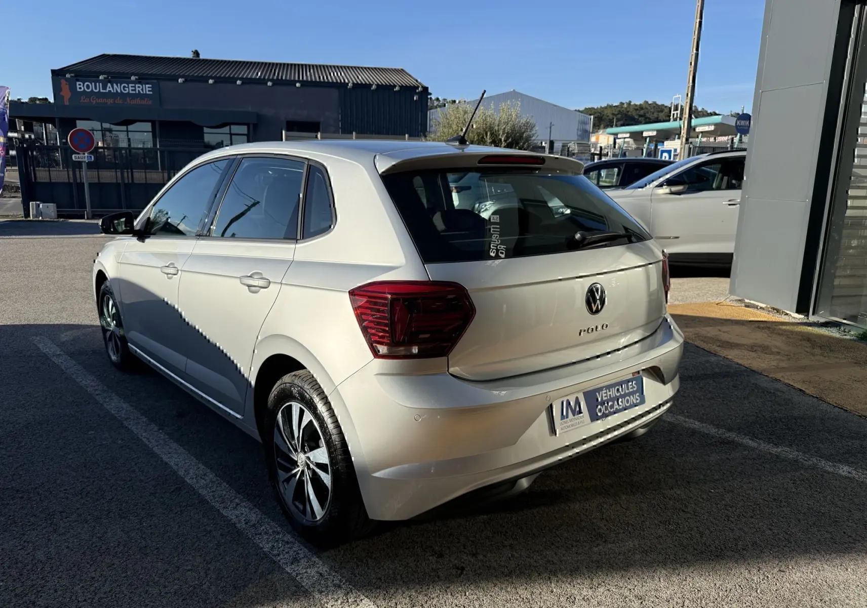 Volkswagen Polo gris métal vue 3/4 arrière droit, avec feux arrière foncés et jantes alliage distinctives.