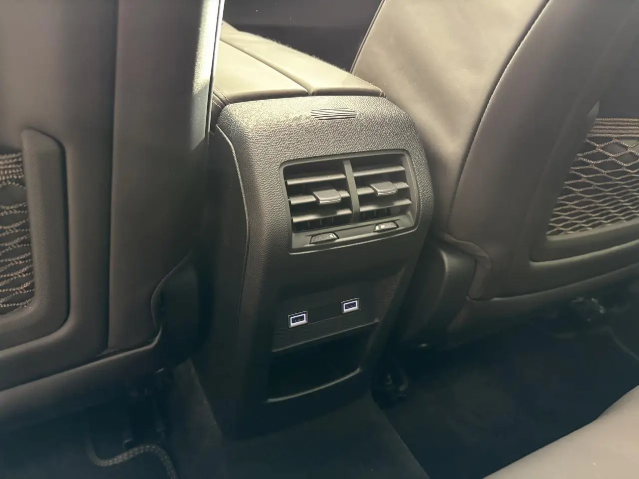 Vue rapprochée de la console centrale arrière noire avec aérateurs et deux prises USB-C du DS4 E-Tense 2023.