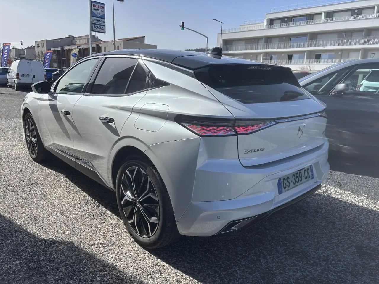 Vue 3/4 arrière droite du DS4 E-Tense 2023 avec toit noir Perla Nera et feux arrière LED effet 3D.