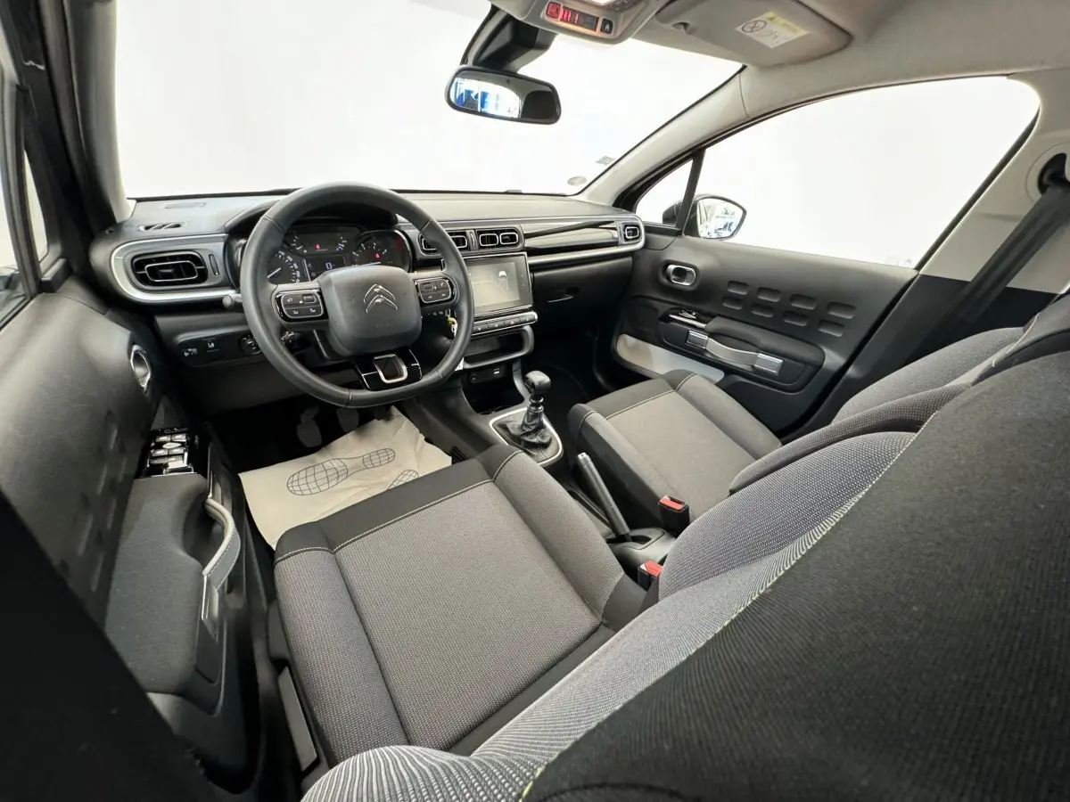 Vue intérieure avant droite de la Citroën C3 2020, sièges gris, volant cuir multifonctions et écran tactile central.