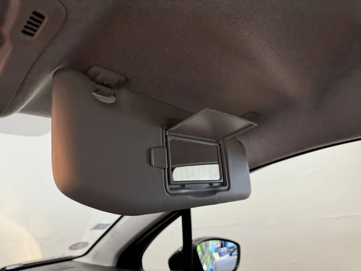 Détail intérieur du pare-soleil côté conducteur avec miroir ouvert sur Citroën C3 gris foncé, vue depuis l'habitacle.