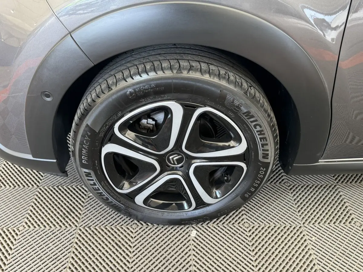 Gros plan sur la roue arrière droite gris foncé d'une Citroën C3 avec jante noire et argentée au design moderne.