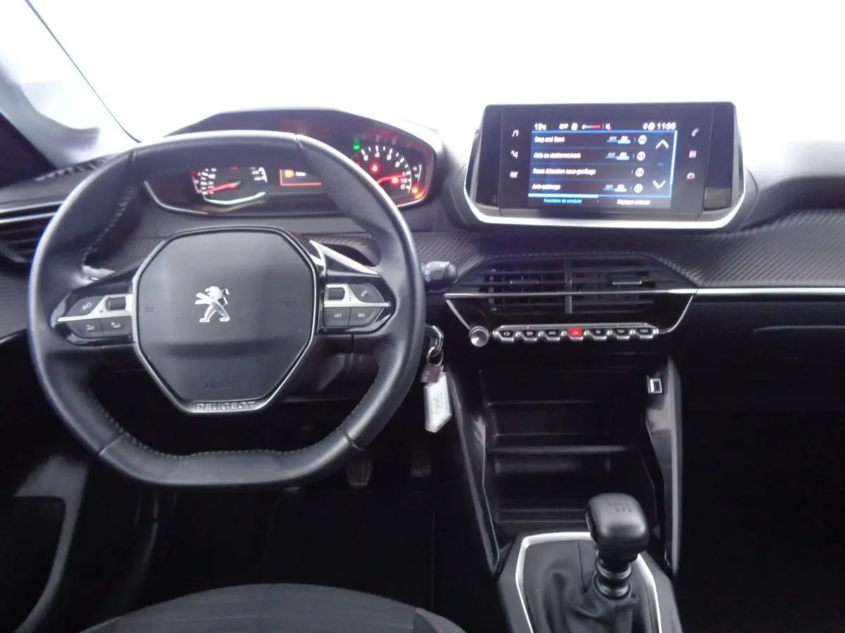Vue intérieure centrée sur le tableau de bord et volant noir de la Peugeot 208 1.5 BlueHDi 2020