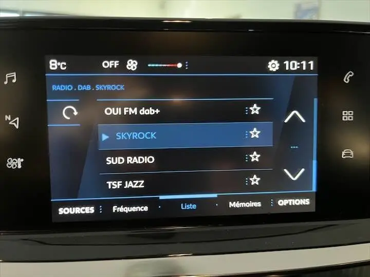 Écran tactile central de la Peugeot 208 affichant la liste des radios numériques avec Skyrock en surbrillance.