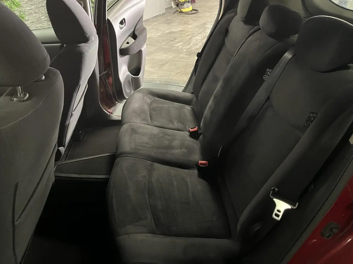 Vue intérieure côté droit sur les sièges arrière en tissu noir du Nissan Leaf 30 2017 rouge avec porte ouverte.