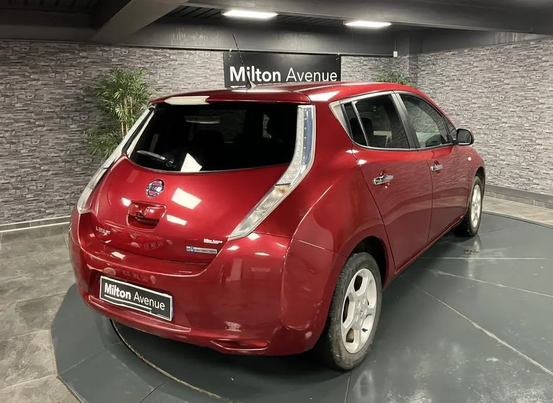 Vue 3/4 arrière droite d'une Nissan Leaf rouge métallisée 2017 avec feux arrière verticaux distinctifs.