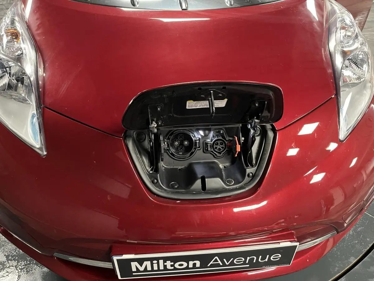 Vue rapprochée de l'avant rouge d'une Nissan LEAF 2017 avec la trappe de recharge électrique ouverte.