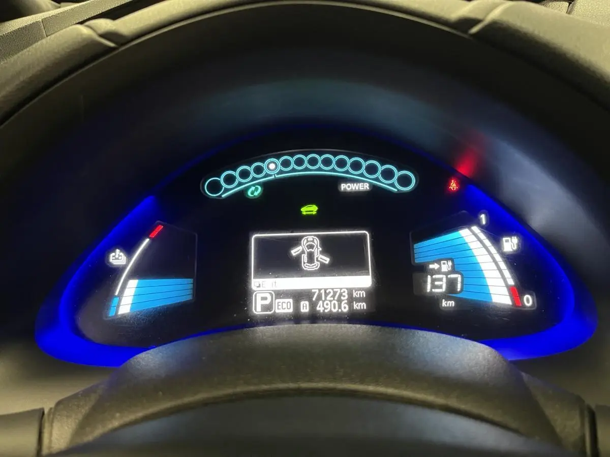 Tableau de bord éclairé de la Nissan Leaf 30 2017 rouge, affichant autonomie et indicateurs de charge électrique.